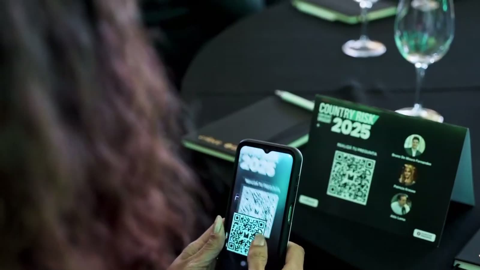 Asistente escaneando con el teléfono el código QR de la mesa para enviar una pregunta
